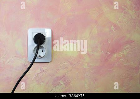 White socket and cable on pink wall. Double socket Stock Photo