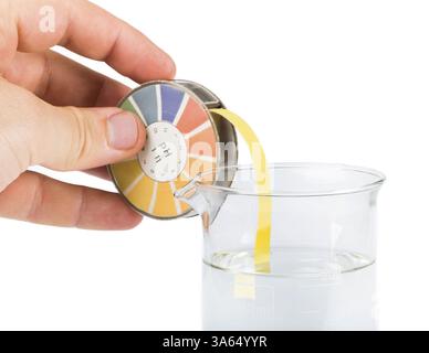 Litmus paper and beaker. Hand holding litmus paper Stock Photo