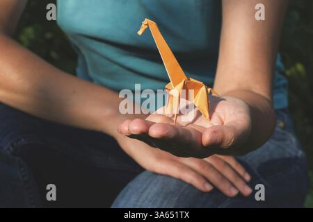 Origami orange color giraffe on hand Stock Photo