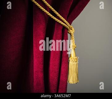 Red velvet curtain with tassel. Close up Stock Photo