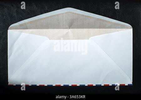 Open vintage envelope on black background. Red and blue lines Stock Photo