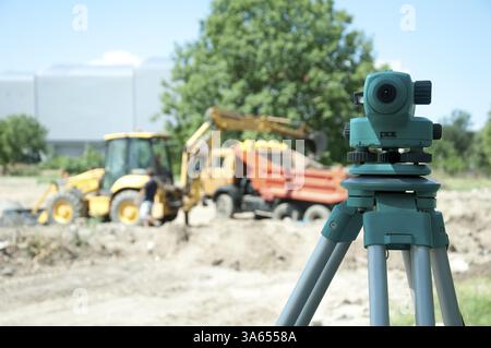 Surveying equipment to the construction site. Excavator and truck on the background Stock Photo