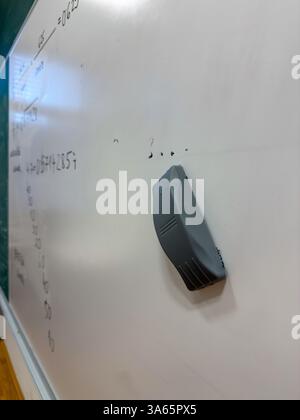 Whiteboard with Eraser and Math Equations in Classroom Stock Photo