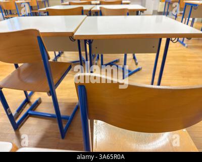 Empty Classroom with Wooden Chairs and White Desks Stock Photo