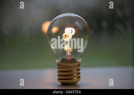 A glowing light bulb representing creativity, innovation, and ideas, placed on a neutral background concepts related to energy, invention, inspiration Stock Photo