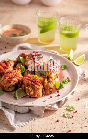 Crispy roasted chicken leg served with lime and herbs. Grilled chicken legs seasoning with herbs and spices. Stock Photo