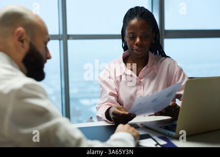 Colleagues Discussing Documents In Office Stock Photo