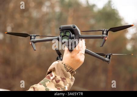 Concept of using drones in modern warfare. Close-up of a drone in hands of a soldier. Military use of drones Stock Photo