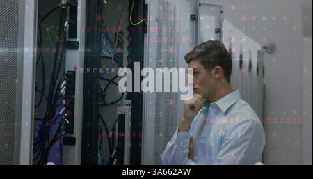 Analyzing server racks, IT professional focusing on cybersecurity issues in data center Stock Photo