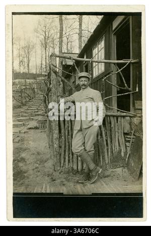 Original WW1 era postcard of handsome French soldier, E Jacquet, wearing a military artillery? uniform, outside a rustic built hut / living quarters behind the lines at Aisne, on the Western Front, France. He wears an impressive moustache! Sent to his wife from the Front. This postcard is dated 7 April 1917 (Holy Saturday) (Easter) sent to and address at Boulogne-sur-Seine, (now Boulogne-Billancourt) Paris, France Stock Photo