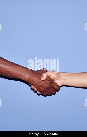 Close-up image capturing handshake between African American and Caucasian hands, symbolizing unity and diversity Stock Photo