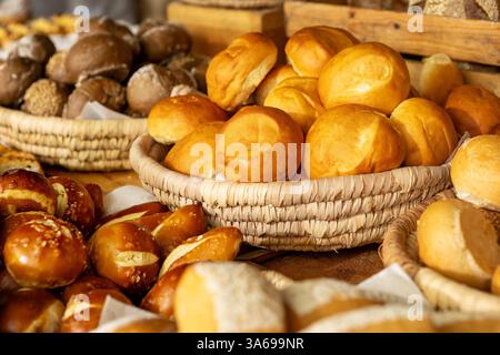 Luxury hotel breakfast buffet with fresh baked bread rolls, artisan pastries and pretzels in rustic wicker baskets. Stock Photo