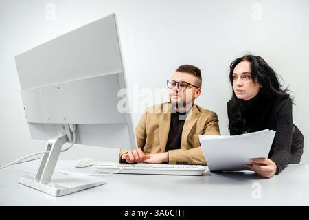 Two generalist business analysts discuss data management using computer. Conceptual consulting, training and customer support using online technology Stock Photo