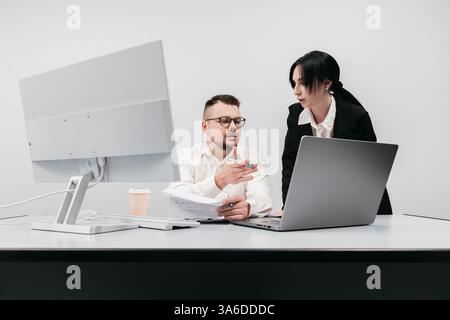 An experienced manager or entrepreneur mentors a new employee in the office. The concept is to convey the process of mentorship, analysis Stock Photo