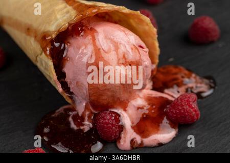 ice cream with red raspberry berries and fresh jam on a black slate board, berry flavored ice cream with fresh raspberries and blackberries Stock Photo