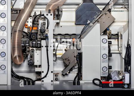 Modern equipment operates methodically, demonstrating precision engineering in a high-tech woodworking production environment. Complex components work Stock Photo