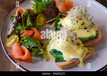 Closeup breakfast plate with eggs benedict, smoked salmon and fresh greens salad Stock Photo