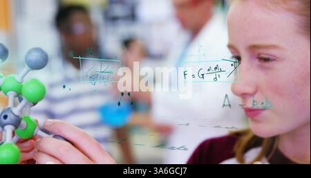 Student examining molecular model in science class, focusing on chemistry equations. education, learning, experimentation, classroom, academic, scient Stock Photo