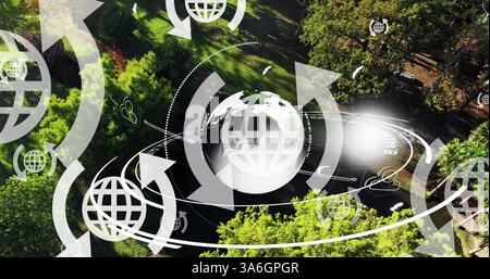 Image of globe icons with arrows and globe spinning over landscape. global travel, connections, digital interface and technology concept digitally gen Stock Photo
