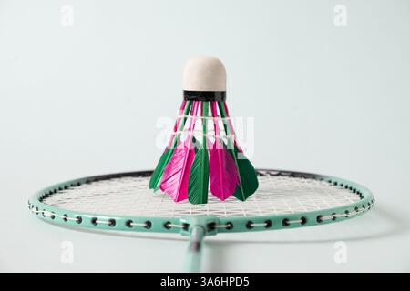 Colorful badminton shuttlecock and badminton racket on blue background. Close up. Concept racket sport. Leisure games. Stock Photo