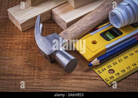 Ruler pencil blueprints wooden bricks construction level and claw hammer on vintage wood board maintenance concept Stock Photo