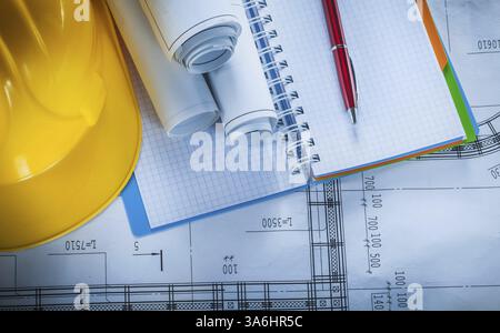 Safety hard hat checked notebook pen blueprints on construction plan Stock Photo