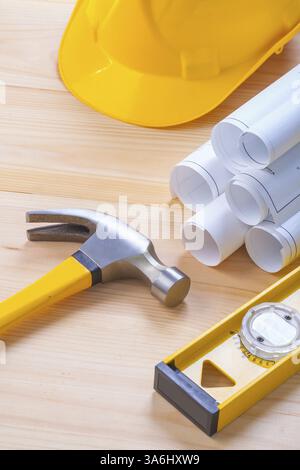 Composition of construction tools hammer level helmet blueprints on wooden board Stock Photo