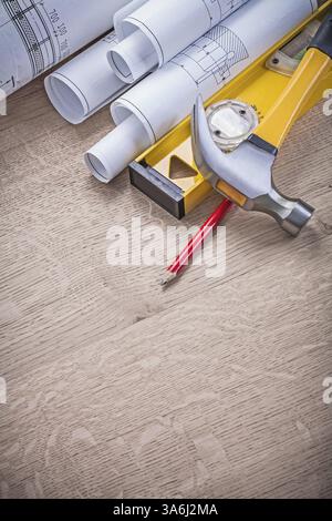 Rolled blueprints hammer level pencil on wood board Stock Photo