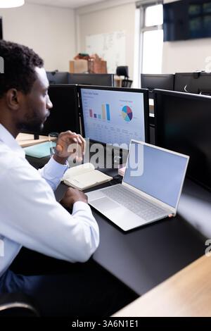 Business professional analyzing sales data on computer at office desk, copy space Stock Photo