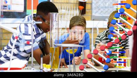 Conducting science experiment with test tubes, students in school focused and engaged. Laboratory, chemistry, education, classroom, learning, research Stock Photo