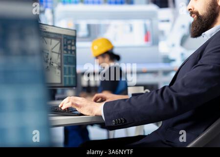 Solar panels manufacturing plant worker analyzing performance data and optimizing efficiency. Photovoltaics factory engineer working on innovative solar cells design prototype Stock Photo