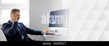 Businessman focused on work while discussing on the phone in modern office Stock Photo