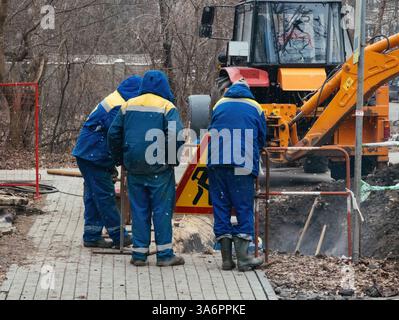 Workers repairing damaged heating or water supply system. Stock Photo