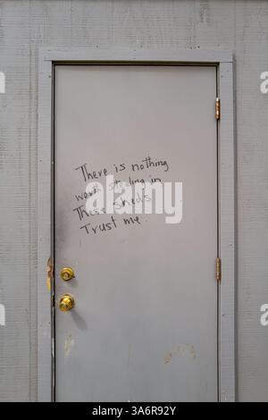 Handwritten sign on outside door that reads There is Nothing Worth Stealing. in these Sheds, Trust Me, to try and deter thieves in downtown Davis, CA Stock Photo