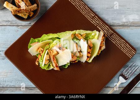 Chicken Caesar salad served on a porcelain plate with crusty bread Stock Photo