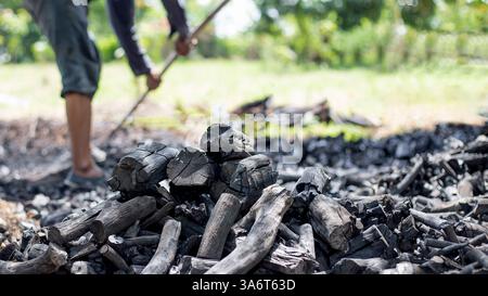 Farmers burn charcoal from wood cut off from the farm. Stock Photo