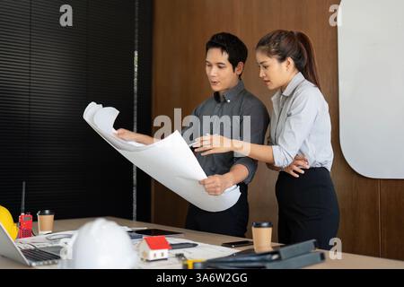 Engineering Collaboration and Project Planning. Two professionals passionately discussing architectural blueprints. Stock Photo