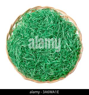 Paper Easter grass in a wicker basket, from above. Green wrinkled shred for filling and decorating, arranged in the shape of a nest. Stock Photo