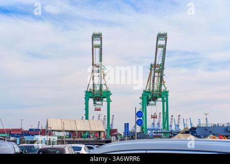 Los Angeles, California - December 25, 2024: Two towering container cranes positioned at the Port of Los Angeles, surrounded by cargo ships and vehicl Stock Photo