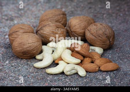 Walnuts, almonds, cashews on cement background. Healthy and tasty snack Stock Photo