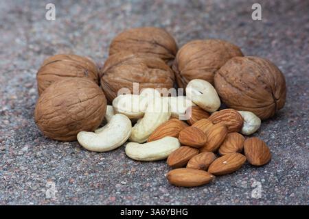 Walnuts, almonds, cashews on cement background. Healthy and tasty snack Stock Photo