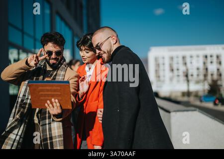 Three young entrepreneurs collaborate outdoors with digital tablet under a clear sky Stock Photo