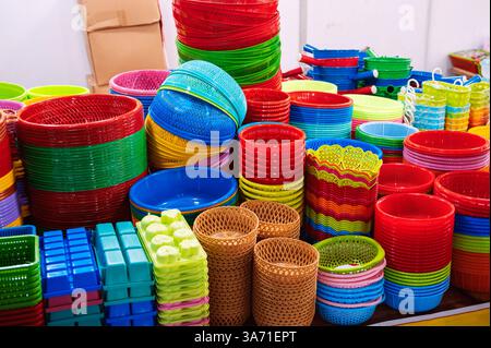 Close-up view of a vibrant stack of plastic bowls and baskets at a market. Stock Photo