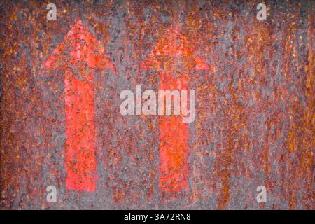Rusty metallic background with two red arrows as a hint. Stock Photo