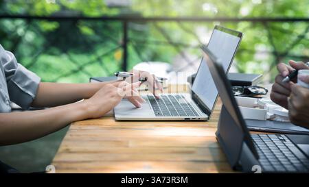 Two young business women sitting at table using laptop in coffee shop cafe. Blogging Freelancers working. Woman using smartphone, business meeting. Stock Photo