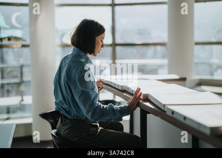 Young professional analyzing documents in modern office setting Stock Photo