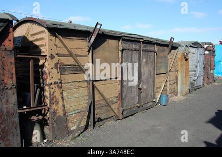 Old railway waggons, in poor condition, repurposed as storage sheds on a British heritage railway Stock Photo
