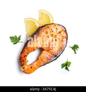 Roasted salmon fish steak isolated on white background, design element. Roasted salmon piece with pepper, lemon and parsley - healthy food ingredient. Stock Photo