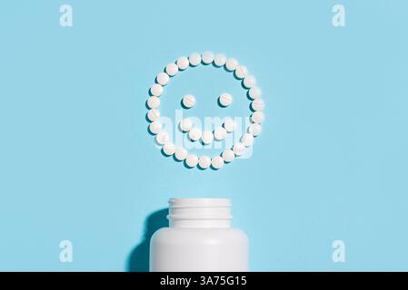 Happy smiling face made of white pills on blue pastel background, top view, copy space. Stock Photo