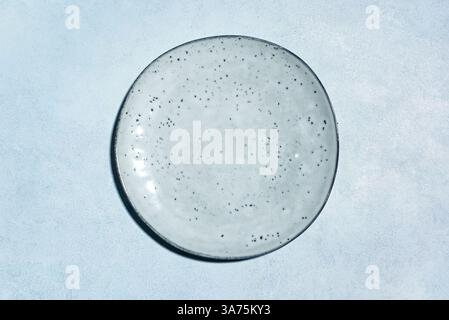 Empty blue ceramic plate on blue concrete background, top view, copy space. Design template with craft ceramic plate. Stock Photo